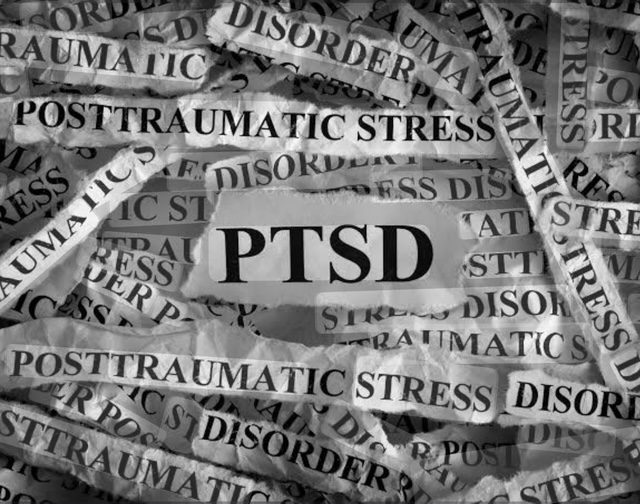 Centered text reads "PTSD" amidst scattered torn papers detailing "Posttraumatic Stress Disorder." Highlights the impact and complexity of PTSD awareness.
