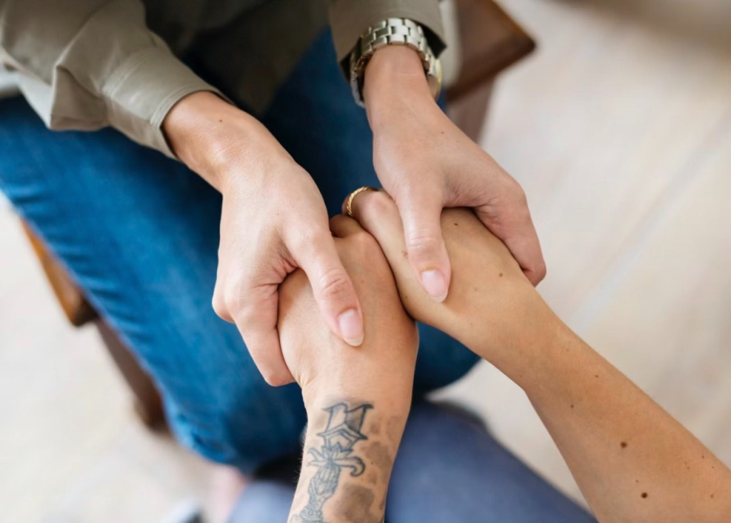Hands joining together in support, symbolizing connection and empathy. Relevant to themes of community and collaboration.