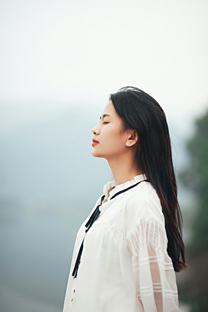 Peaceful outdoor portrait of a woman enjoying tranquility.